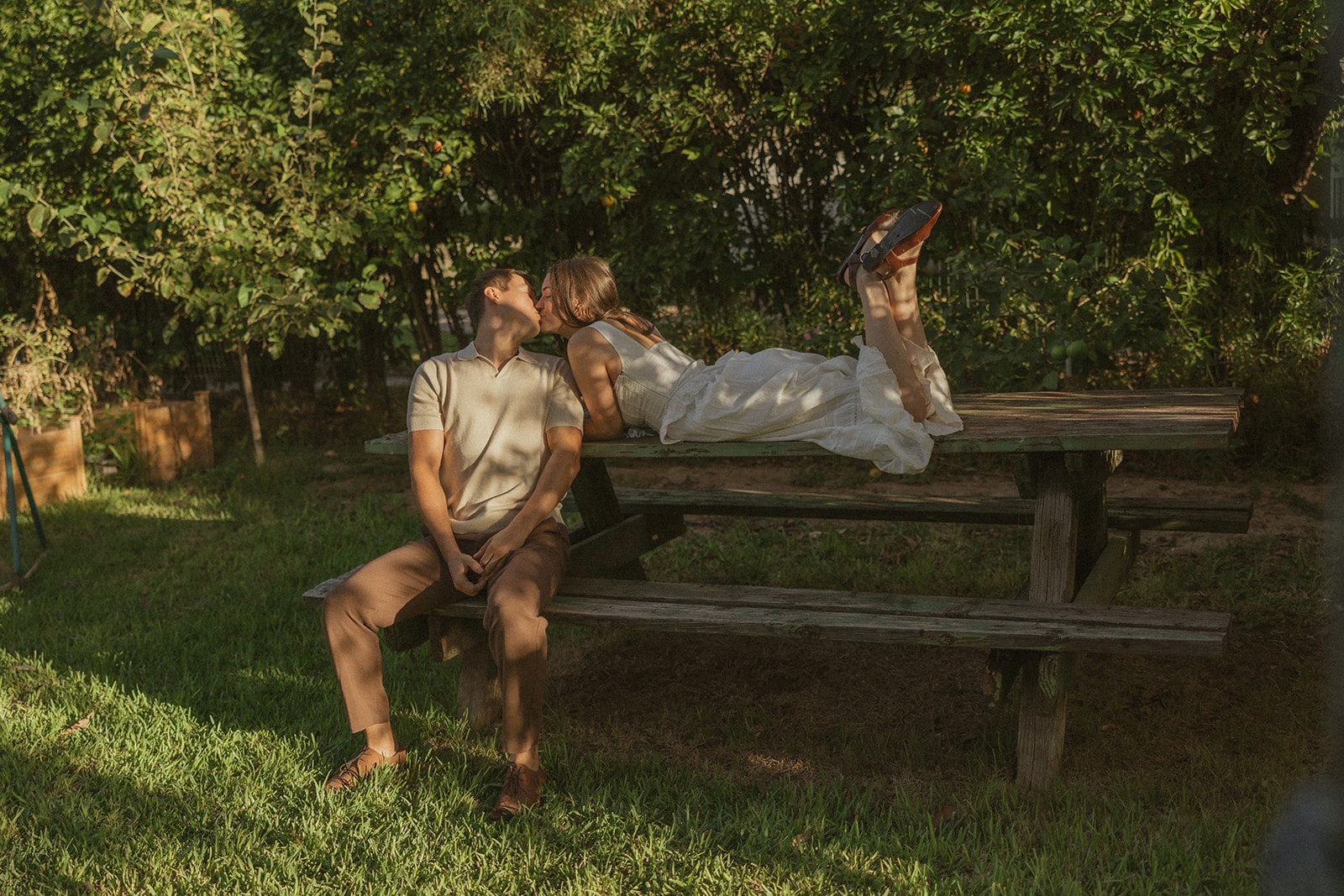 A couple kissing in their garden engagement photos