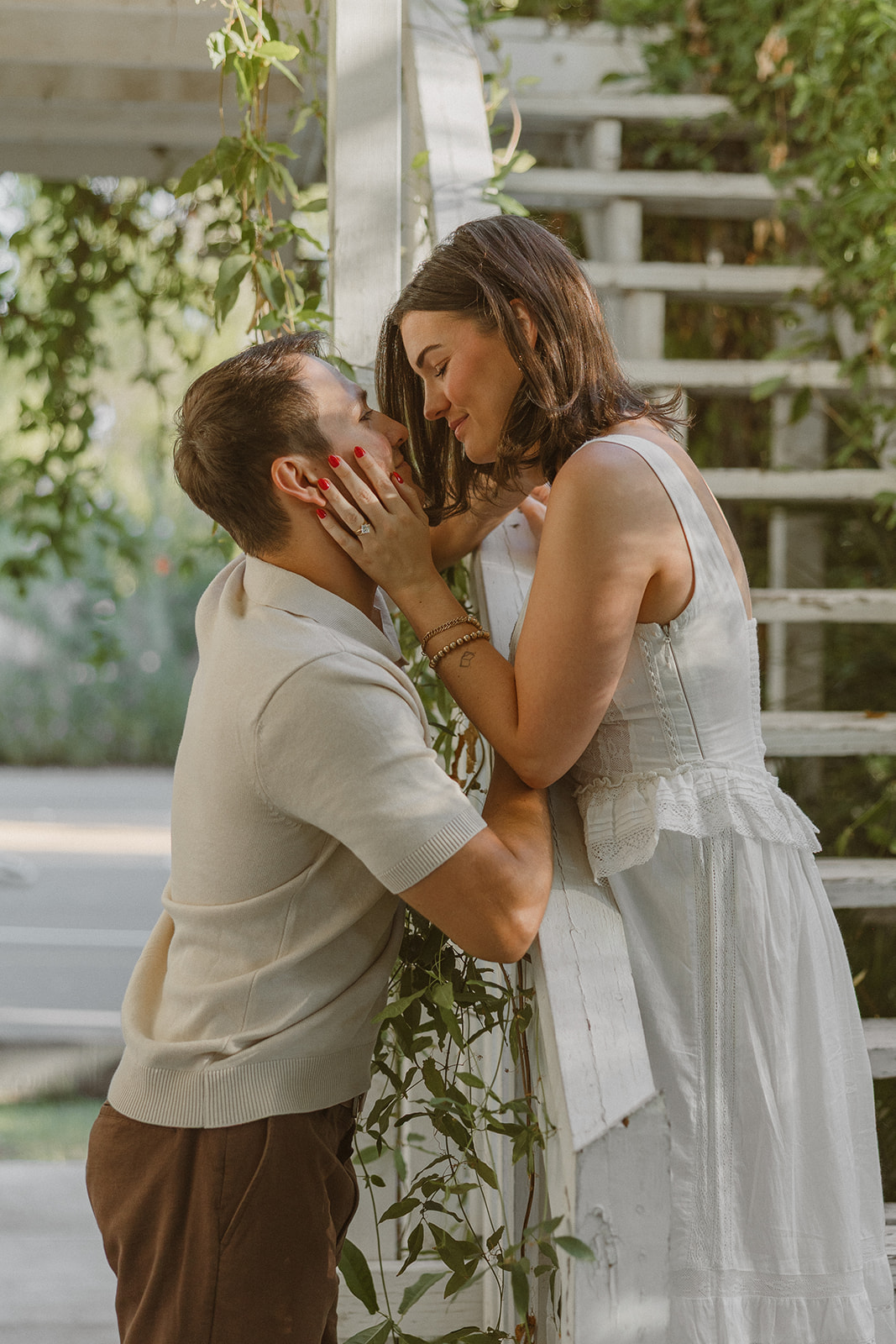 A couple posing on stairs in a garden for engagement photos