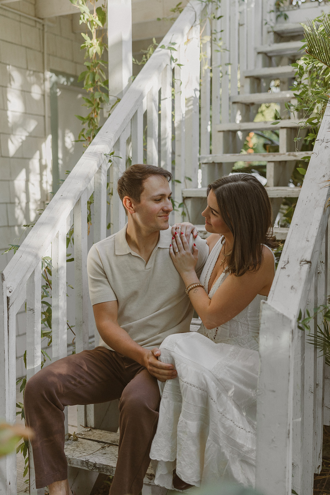 A couple sitting on stairs at the evergreen garden for engagement photos