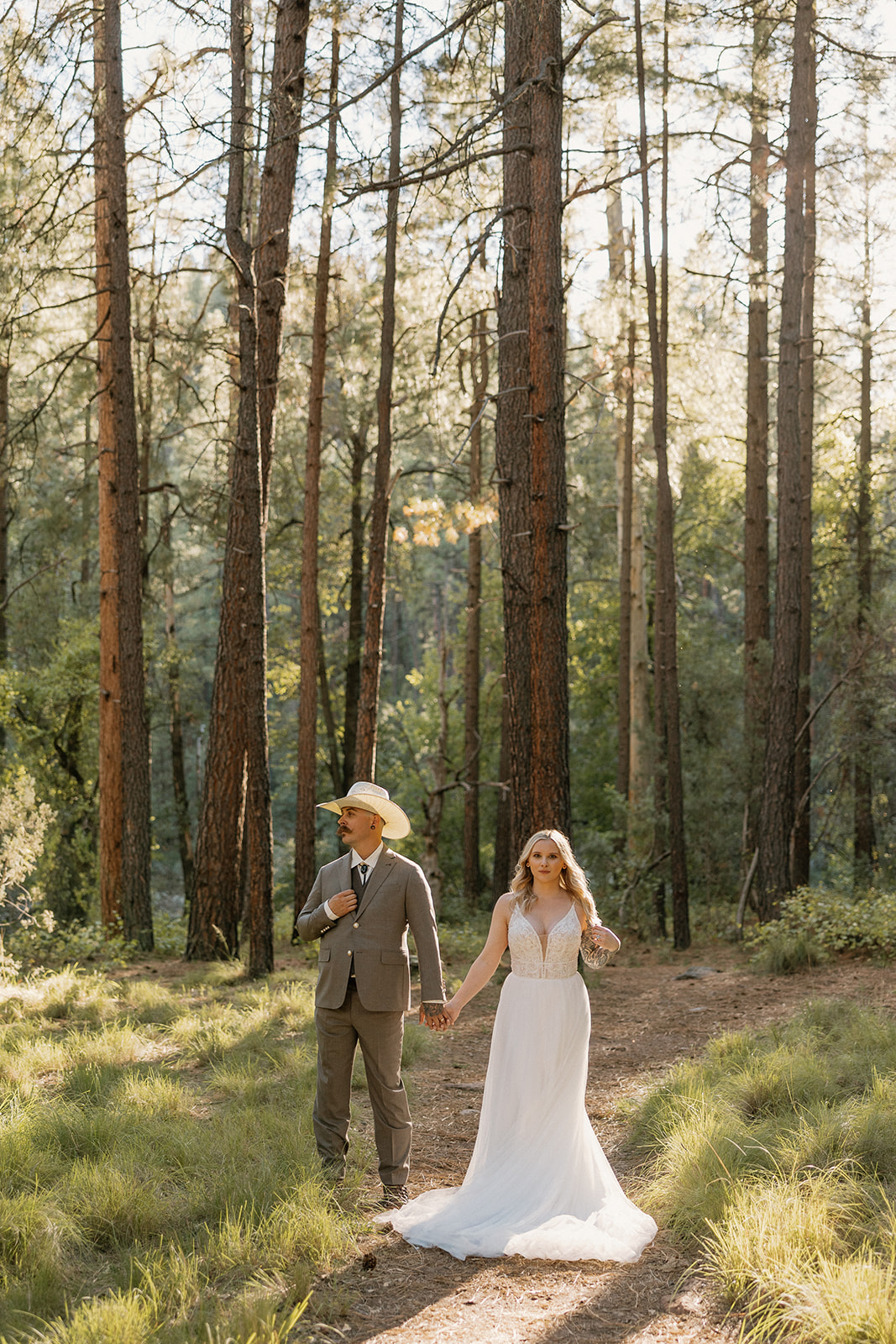 A couple posing for engagement photos in the woods