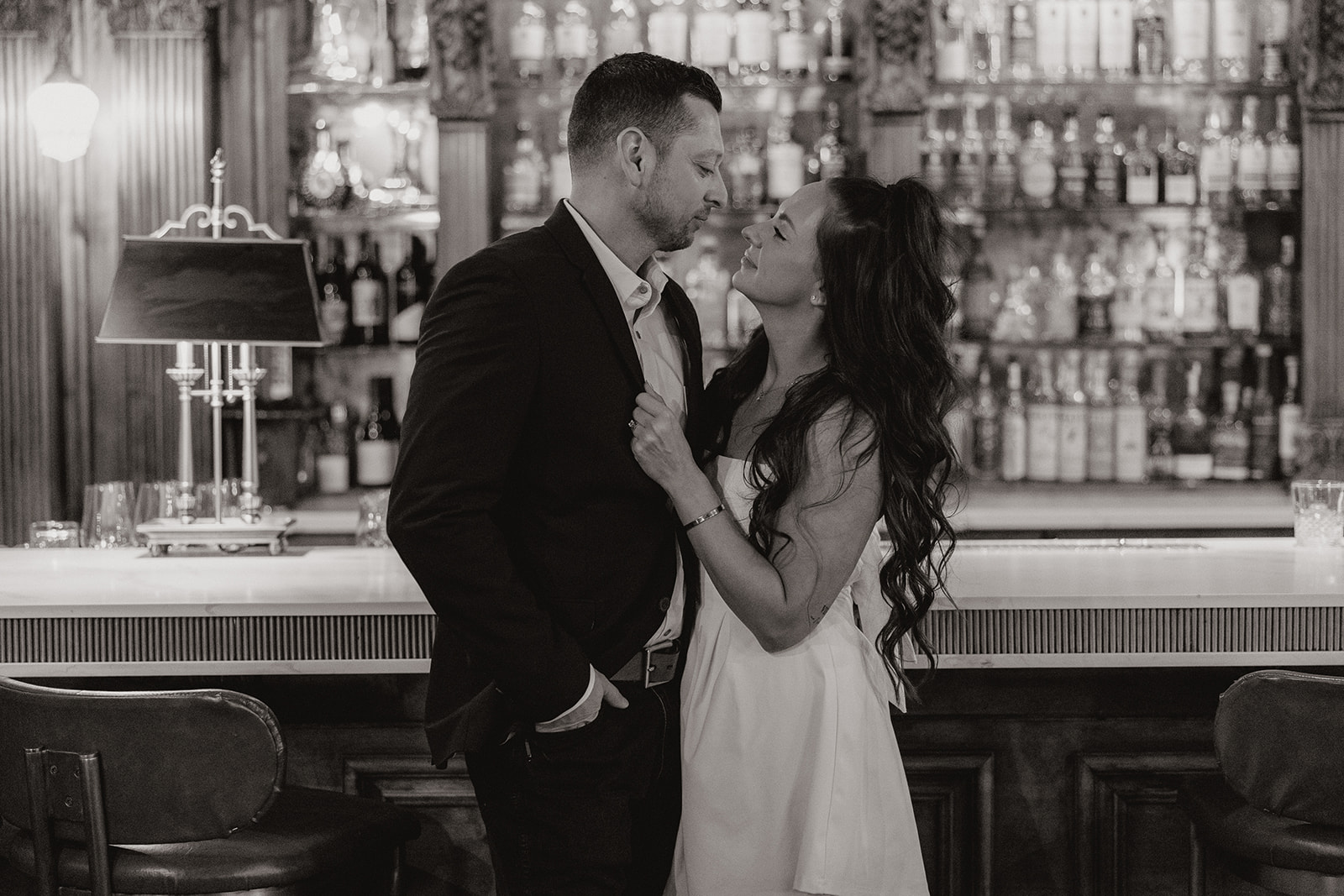 A couple posing for bar engagement photos at a bar engagement photo location