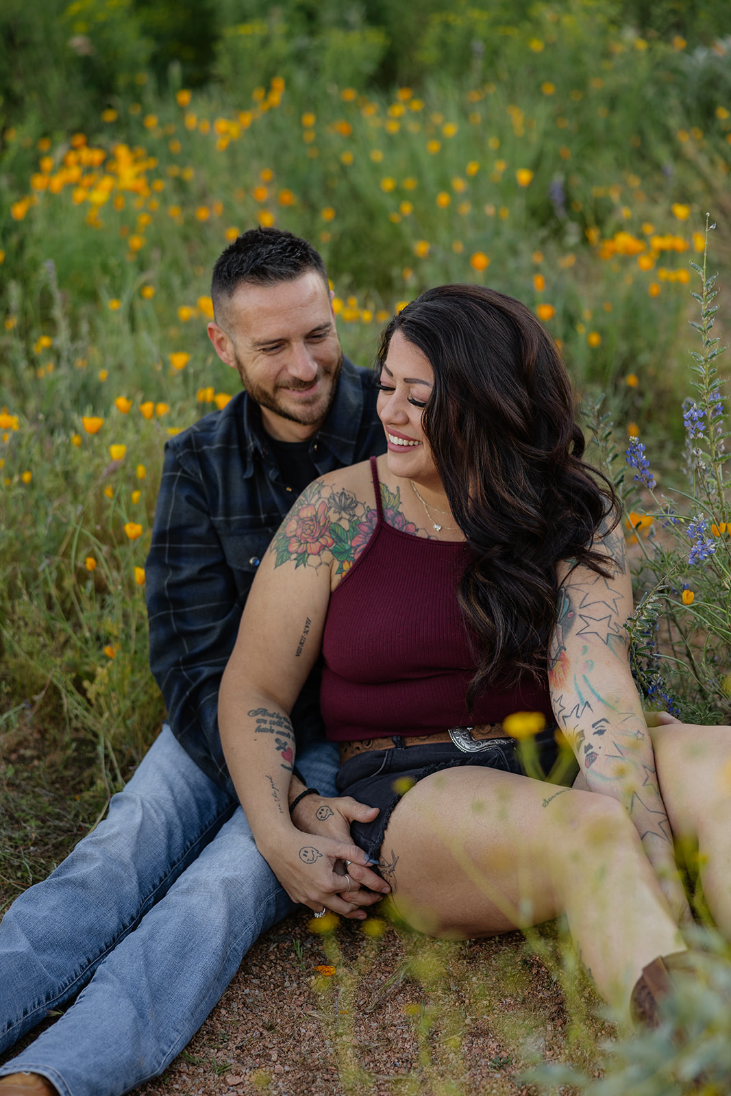 A couple sitting on the ground for engagement photos at Bartlett Lake in Arizona