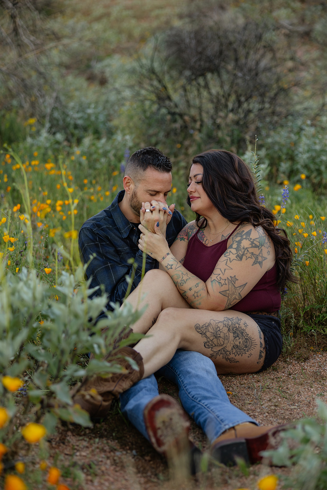 A couple sitting in a field for engagement photos