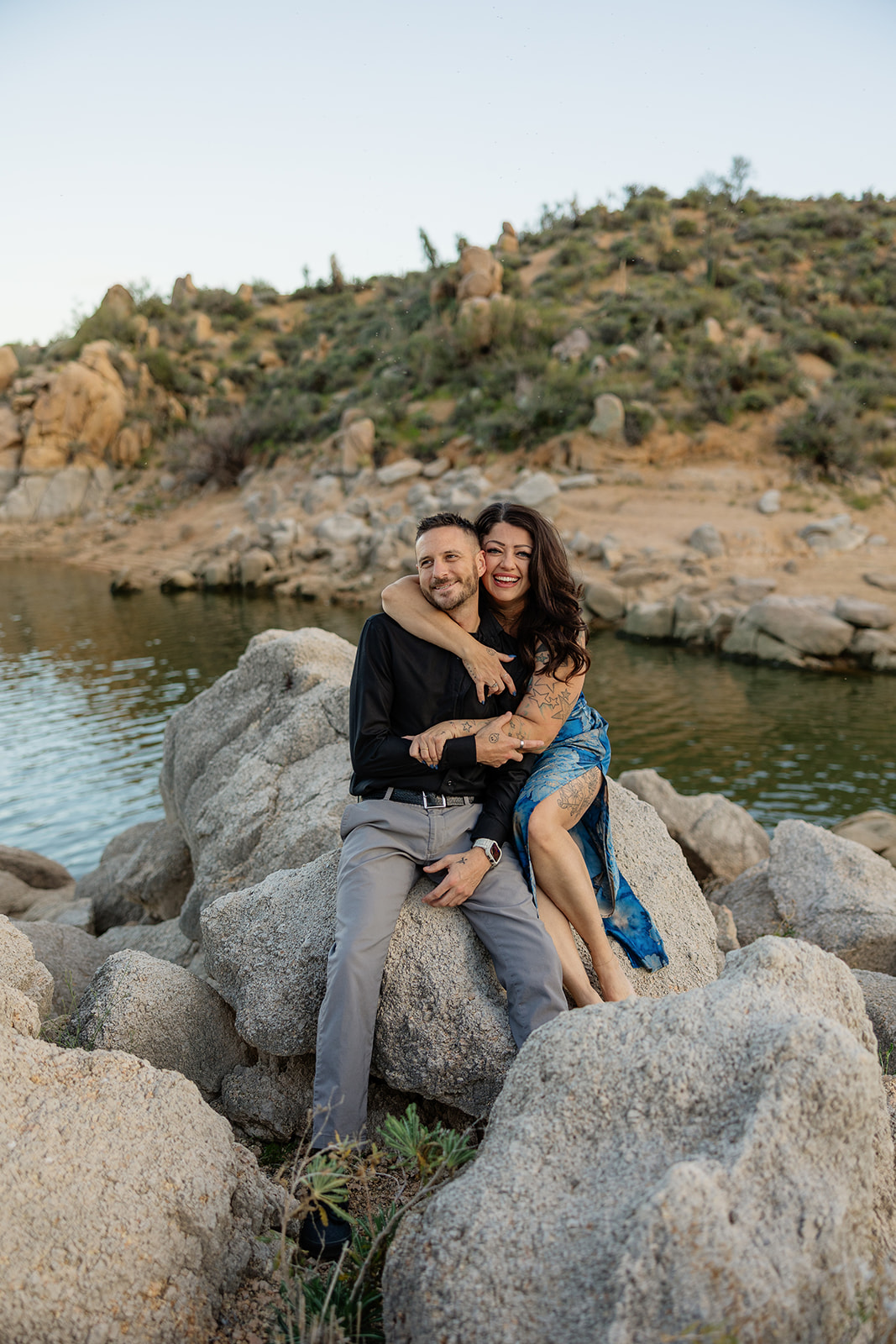 A couple posing for lake engagement photos at Bartlett Lake in Arizona