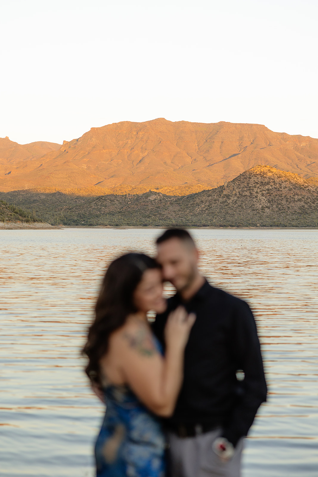 A couple posing for engagement photos in front of Bartlett Lake