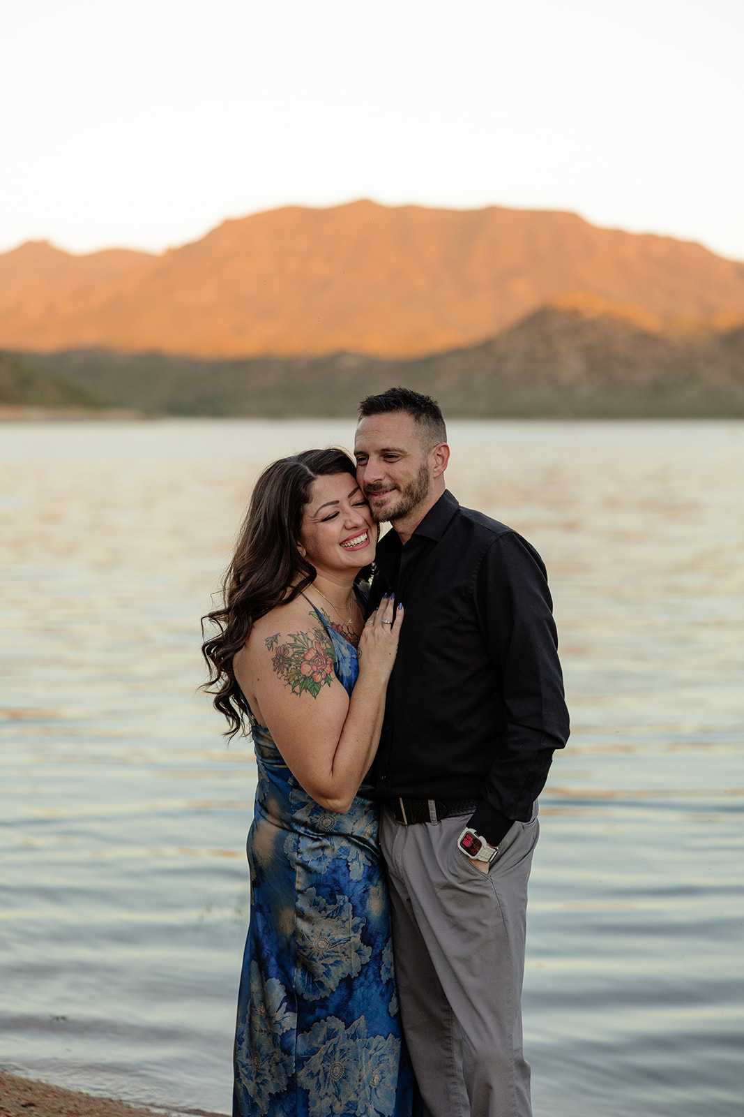 A couple posing for engagement photos in front of Bartlett Lake