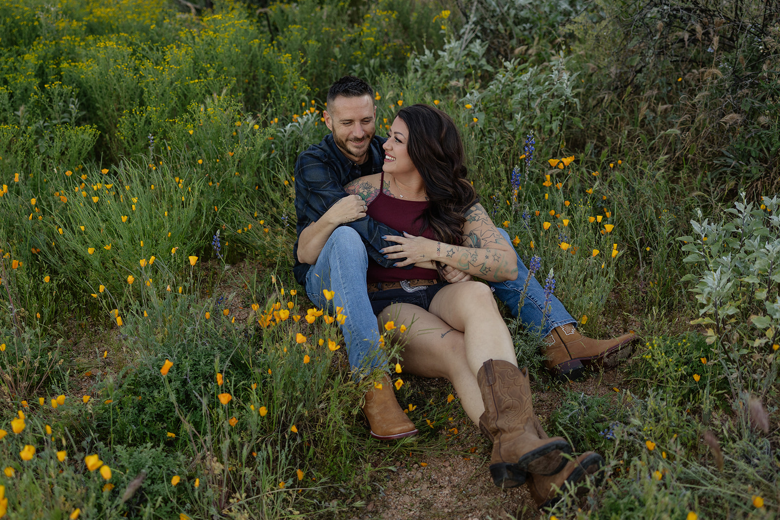 A couple sitting in a wildflower field
